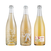 Imagem com três garrafas de vinho, com vidro transparente e cheias de um líquido amarelado, representando três bebidas espumantes da vinícola Vivente. Respectivamente pét-nat Glera/Chardonnay, pét-nat Chardonnay/Pinot Noir e Sidra Macerada.